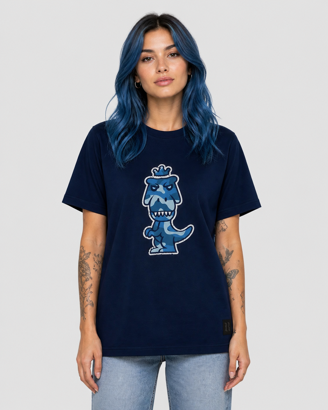 Woman with blue hair wearing navy blue Regno T-Rex Aeris pima cotton tee with luxury blue camo T-Rex graphic, bold monochrome NYC streetwear female lifestyle shot