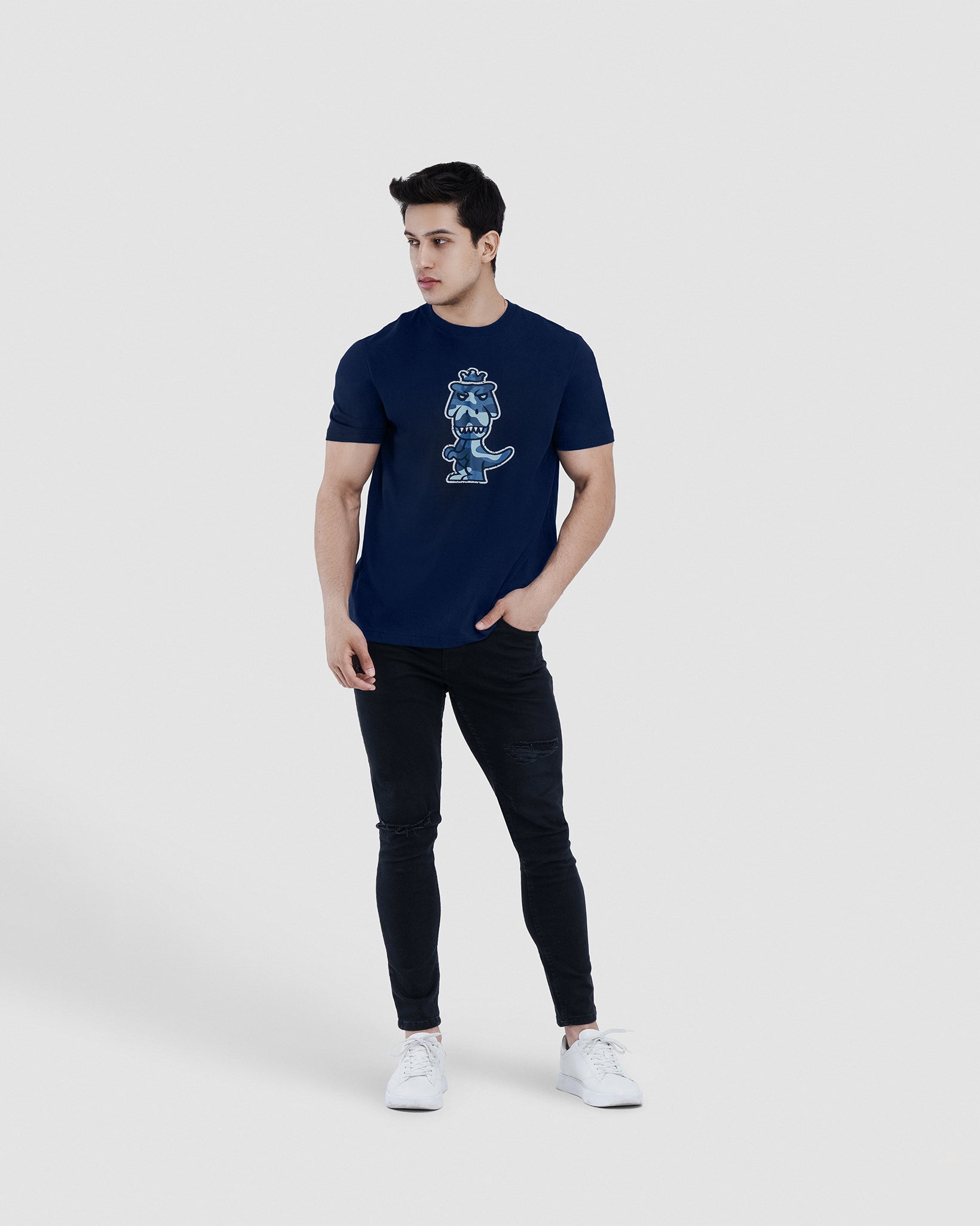 Man wearing navy blue Regno T-Rex Aeris pima cotton t-shirt with luxury blue camo graphic, full body lifestyle shot
