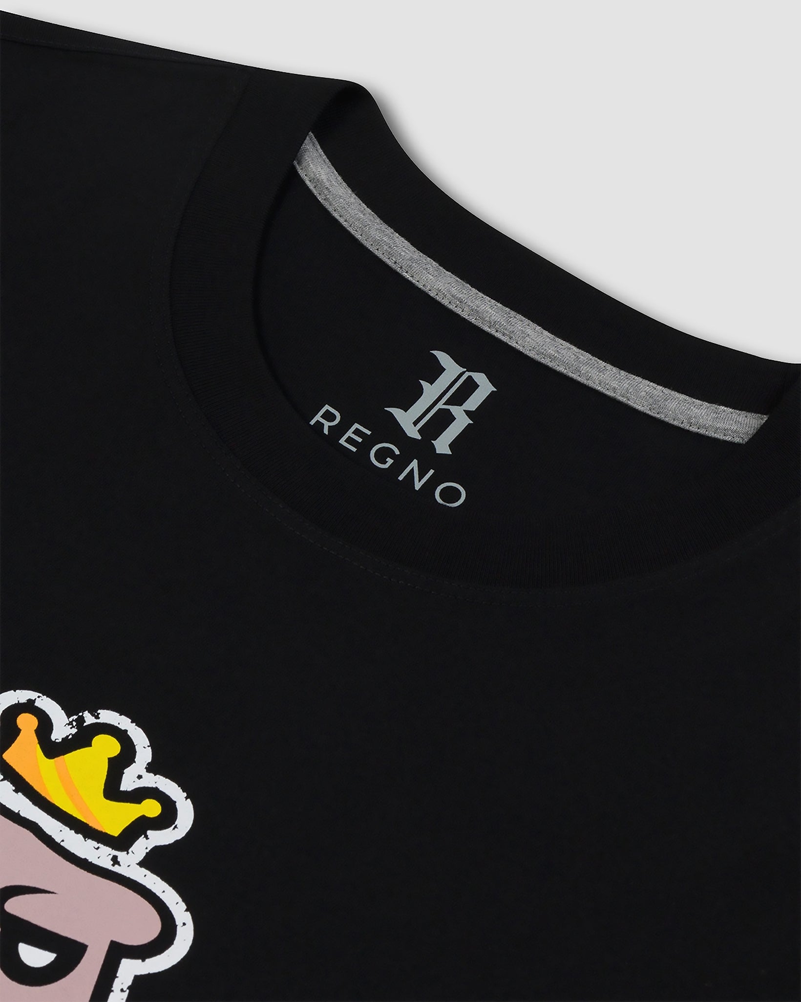 Close-up of minimalist pastel T-Rex graphic on black pima cotton luxury tee by Regno, detail shot