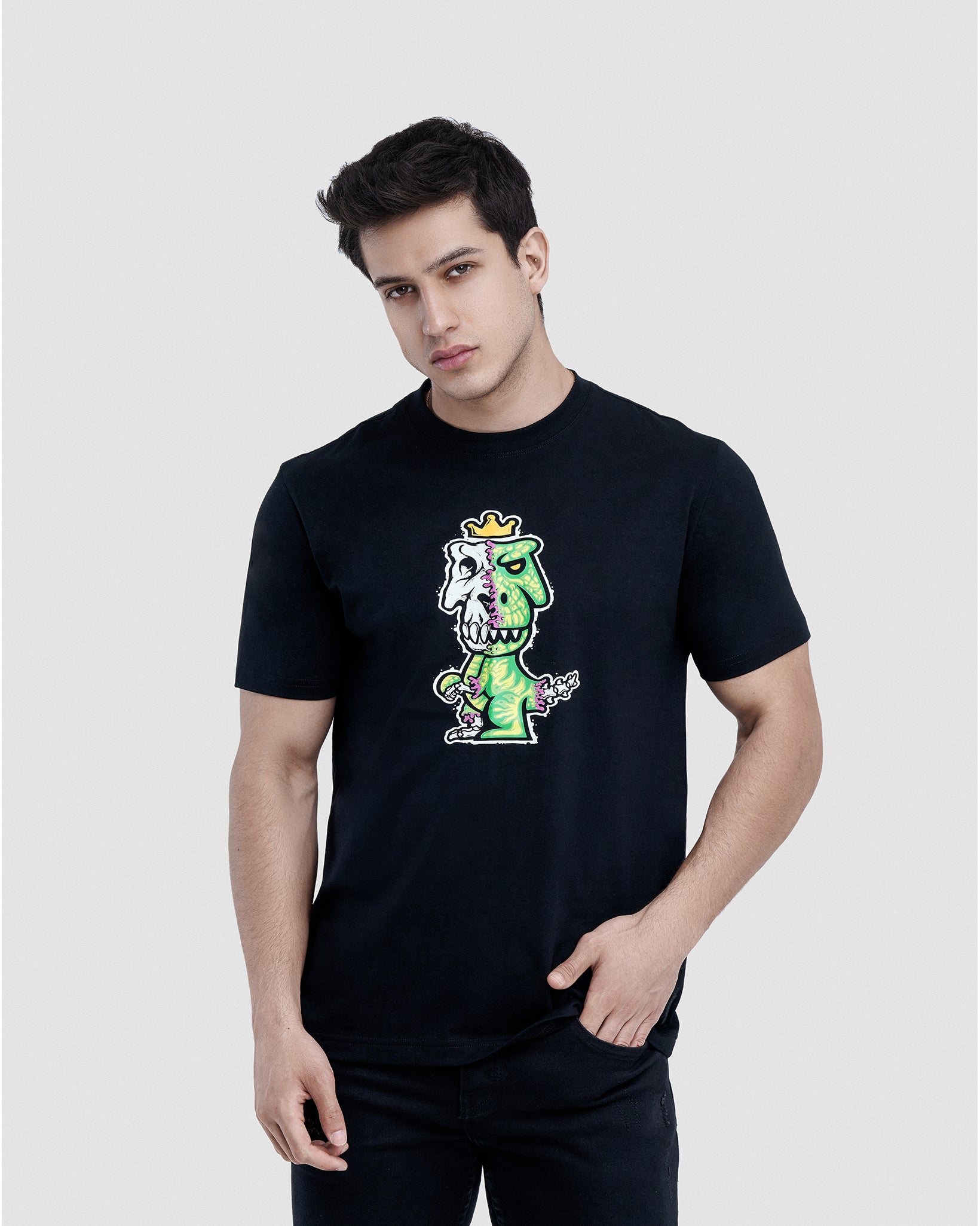 Man wearing black Regno T-Rex Osium pima cotton graphic tee with neon green skeleton T-Rex design, upper body shot