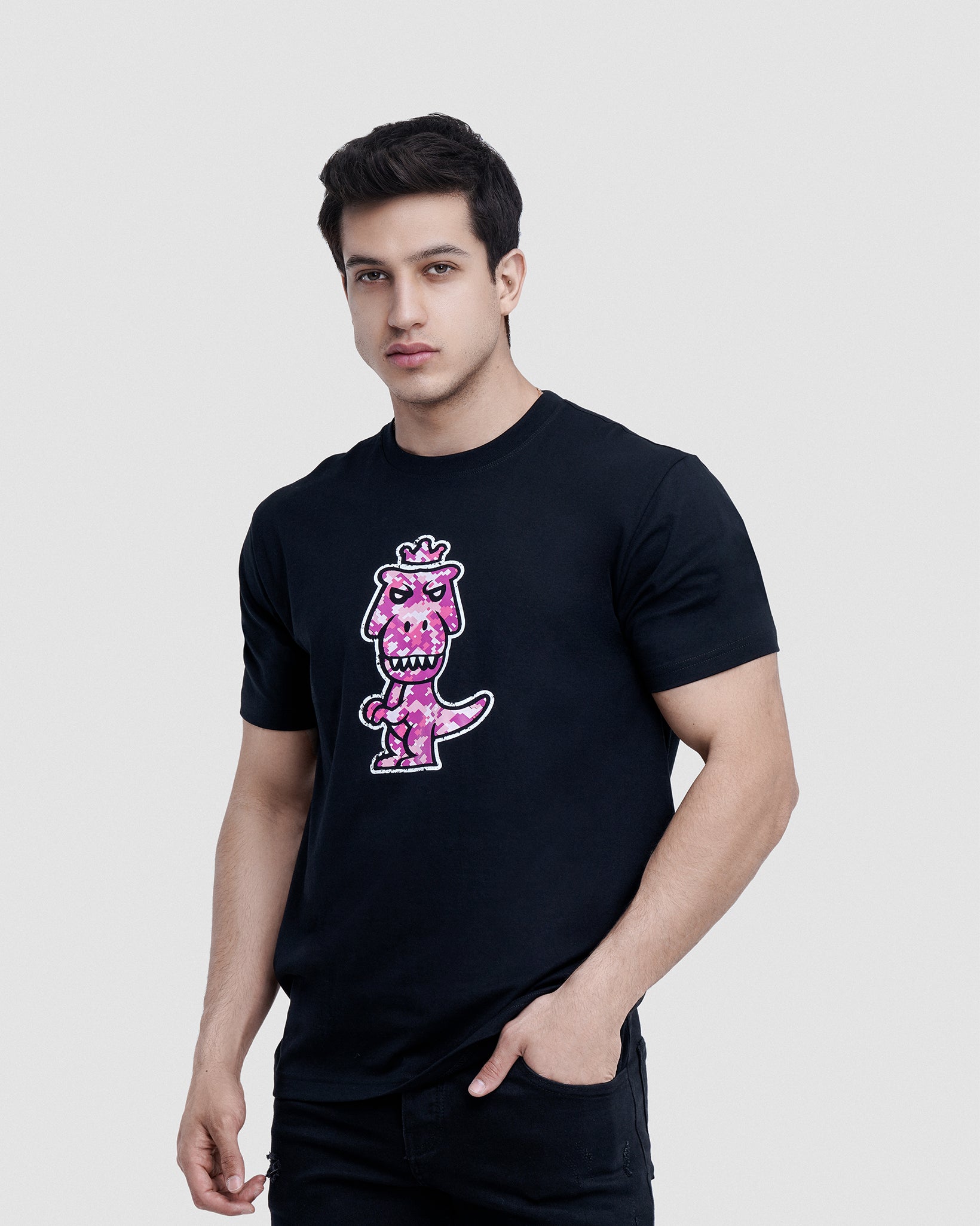 Man wearing black Regno T-Rex Rubesco pima cotton graphic tee with pink pixel T-Rex design, upper body shot