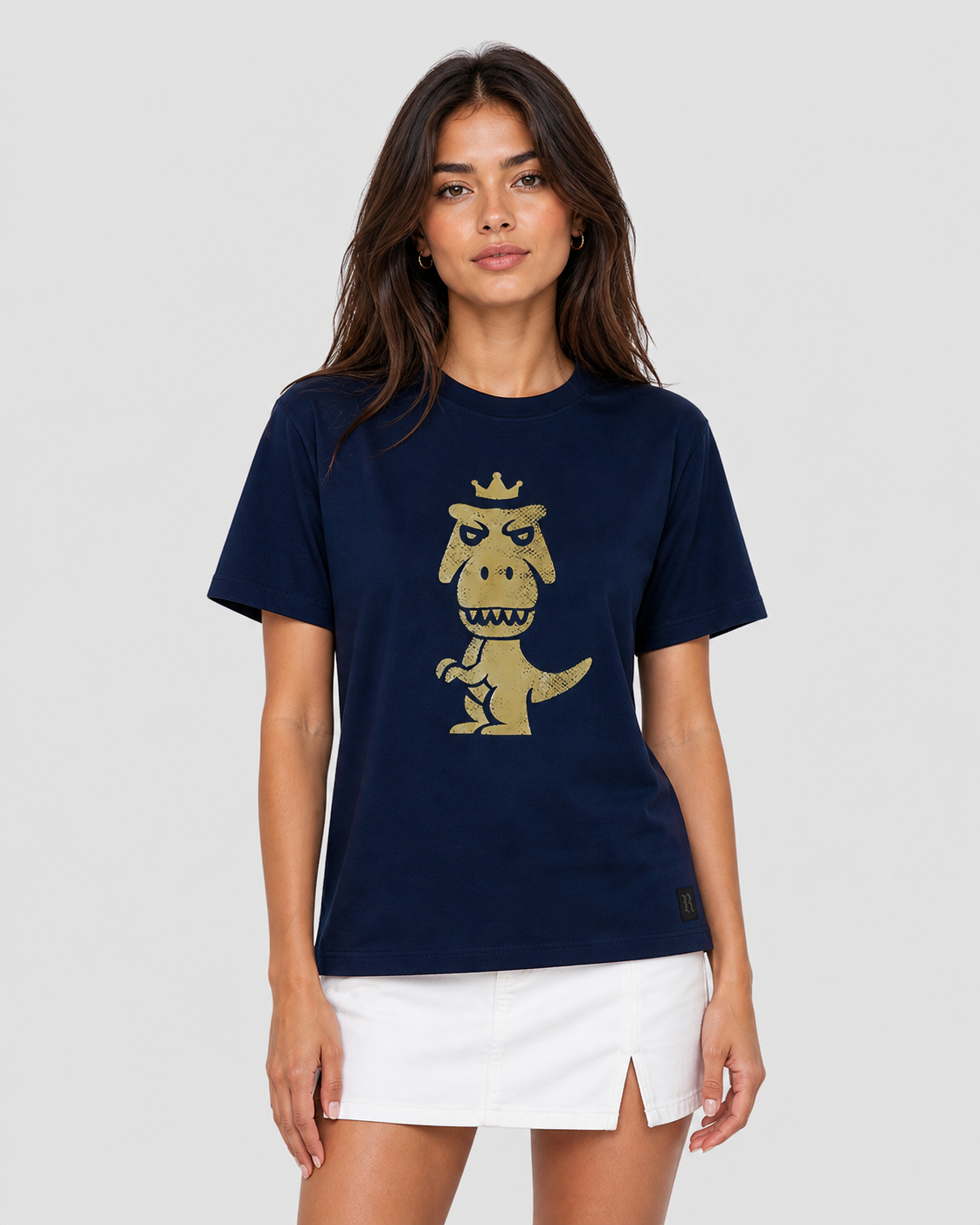 Woman wearing navy blue Regno T-Rex Aurum pima cotton tee with vintage gold T-Rex graphic styled with white mini skirt, luxury streetwear female lifestyle shot