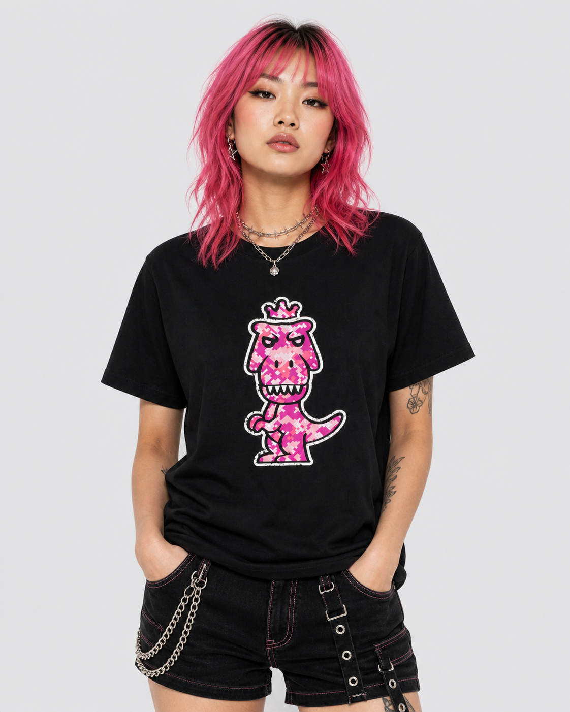 Woman with pink hair wearing black Regno T-Rex Rubesco pima cotton tee with pink pixel arcade T-Rex graphic, edgy NYC streetwear female outfit