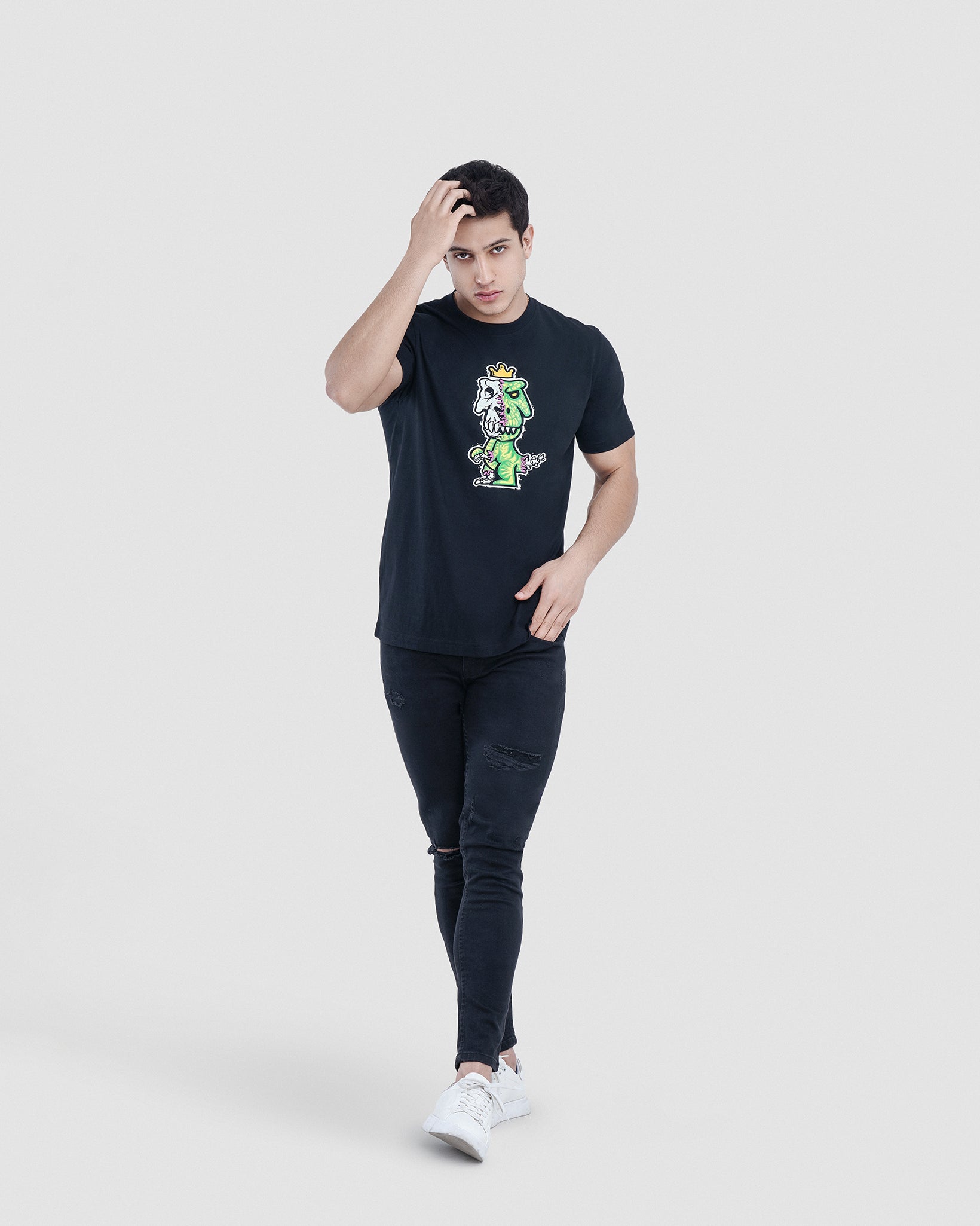 Man wearing black Regno T-Rex Osium pima cotton t-shirt with neon skeleton punk graphic, full body lifestyle shot